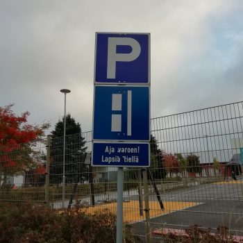 Liikennemerkki koulun pihalla. Aja varoen lapsia tiellä.