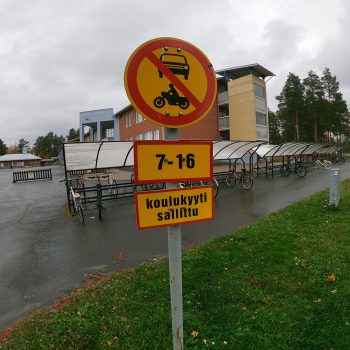 Koulutaksit ajavat suoraan koulun pihalle, pyöräparkkien välittömään läheisyyteen. Fiksusti kouluun -asiantuntijat ehdottivat koulutaksien noutopistettä ajotien reunaan koulun pihan sijasta.