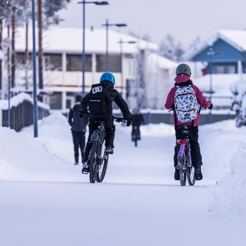 Kaksi lasta pyöräilee talvella.